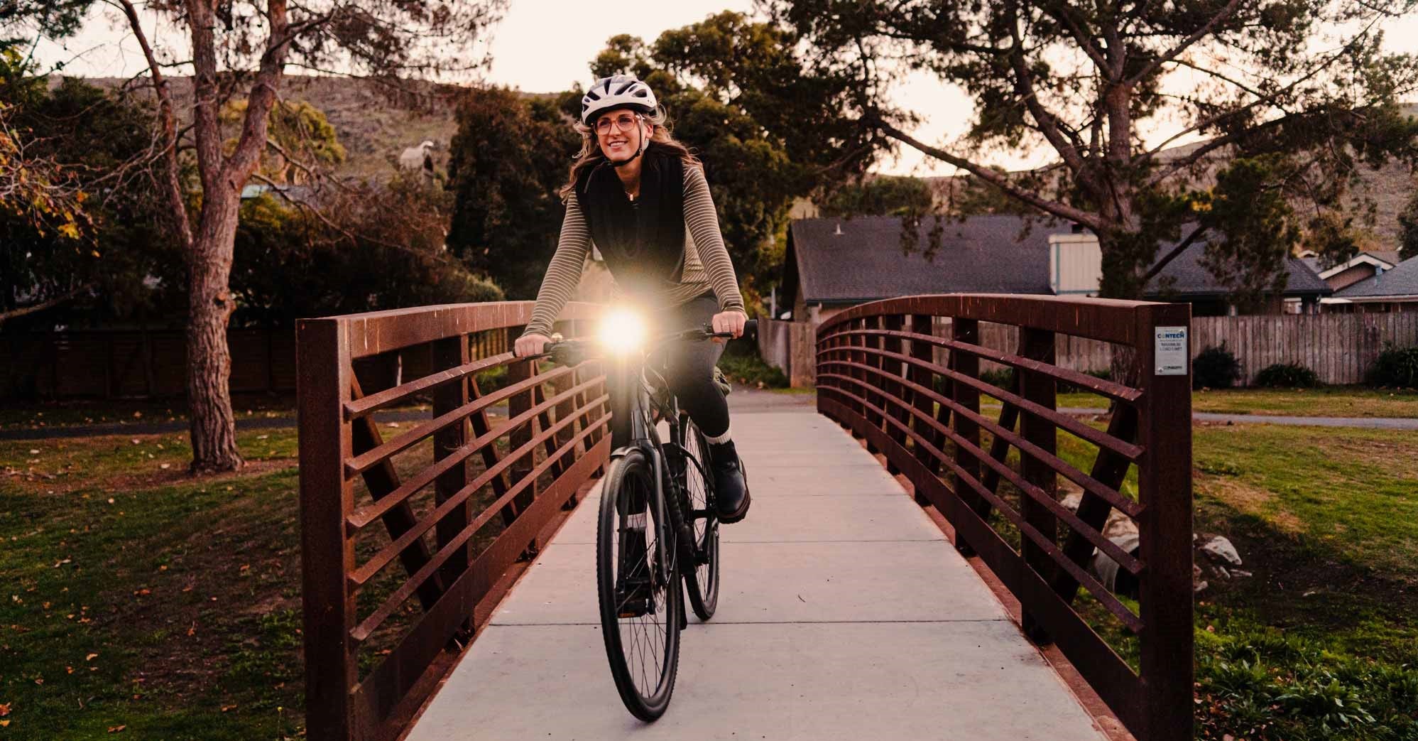 Girl riding a bike during day time with bright light emitting from her front bike light