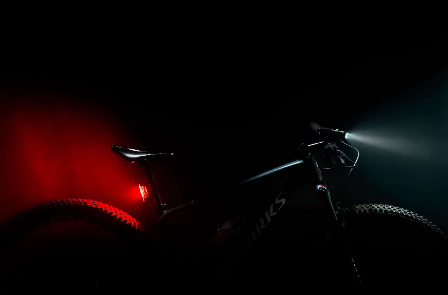 Macro Drive 1400+ front bike light and Strip Drive Pro 400+ rear bike light on a mountain bike.