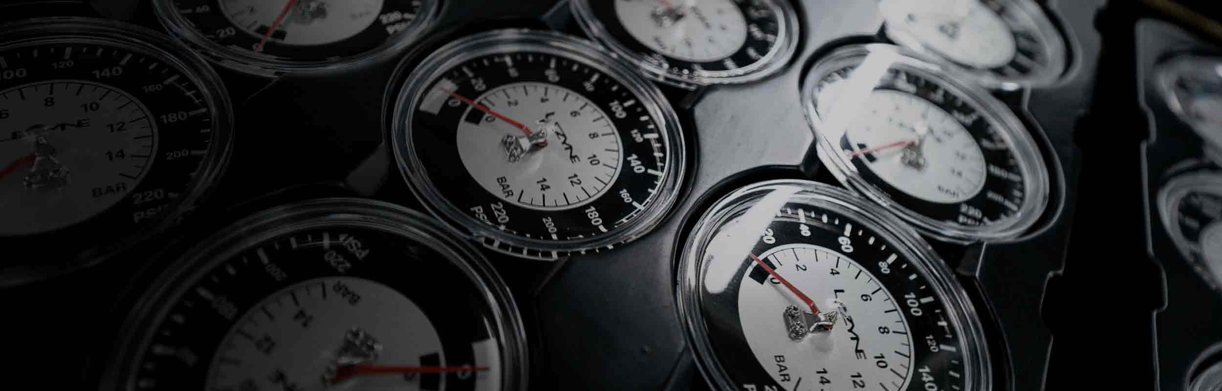 Several analog pressure gauges arranged in a grid.