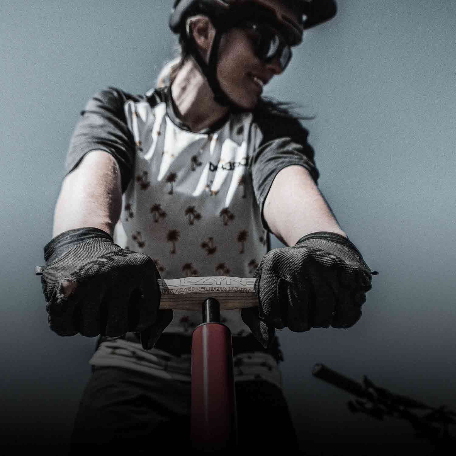 Someone above a floor pump with their hands on the pump handle.