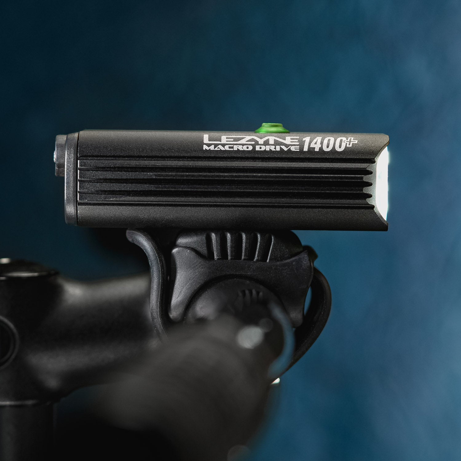 Side view of the MACRO DRIVE 1400+ front LED bike light mounted on road bike handlebar, ideal for cycling after sunset.