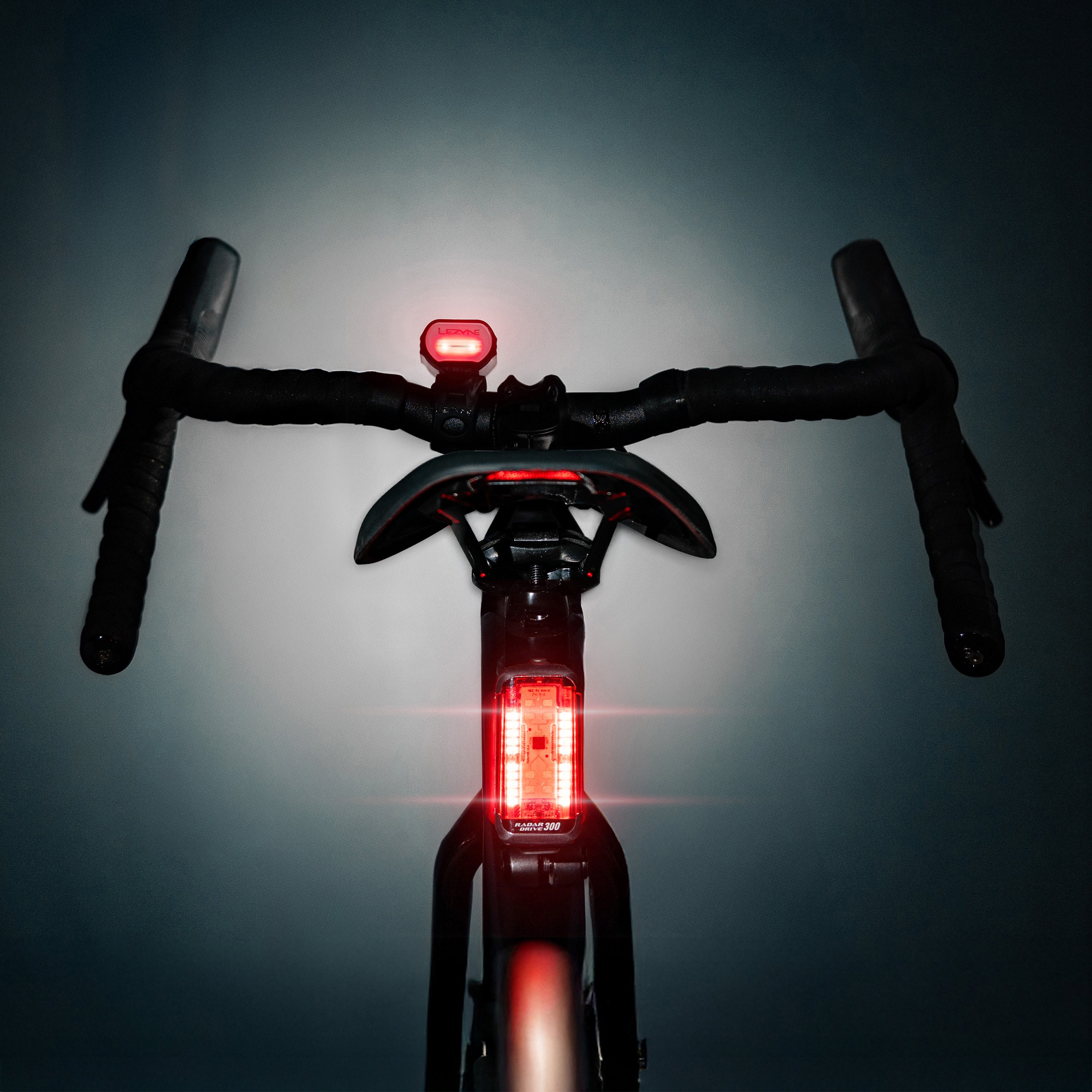 Lezyne Radar React System rear view on road bike; Radar Drive glows and rear indicator LEDs on React Drive are illuminated.