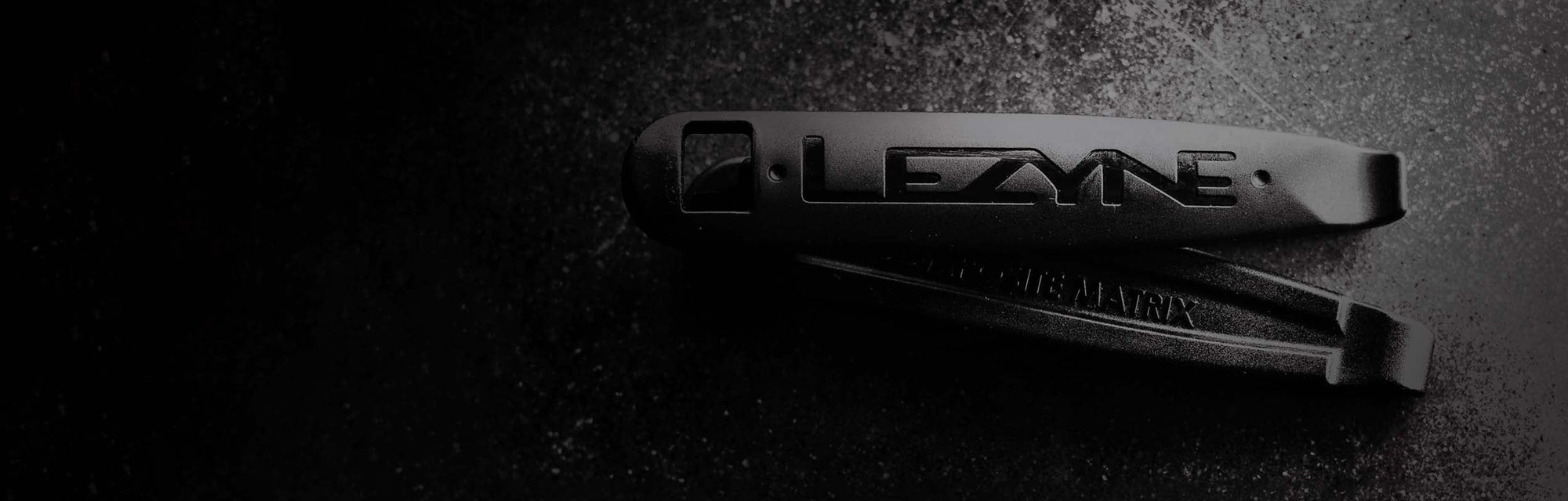 A close up of a tire lever with the word Lezyne printed on it.