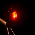 KTV DRIVE+ LED rear bike light mounted on commuter bike seat post, emitting a powerful red light for maximum visibility & safety in traffic.