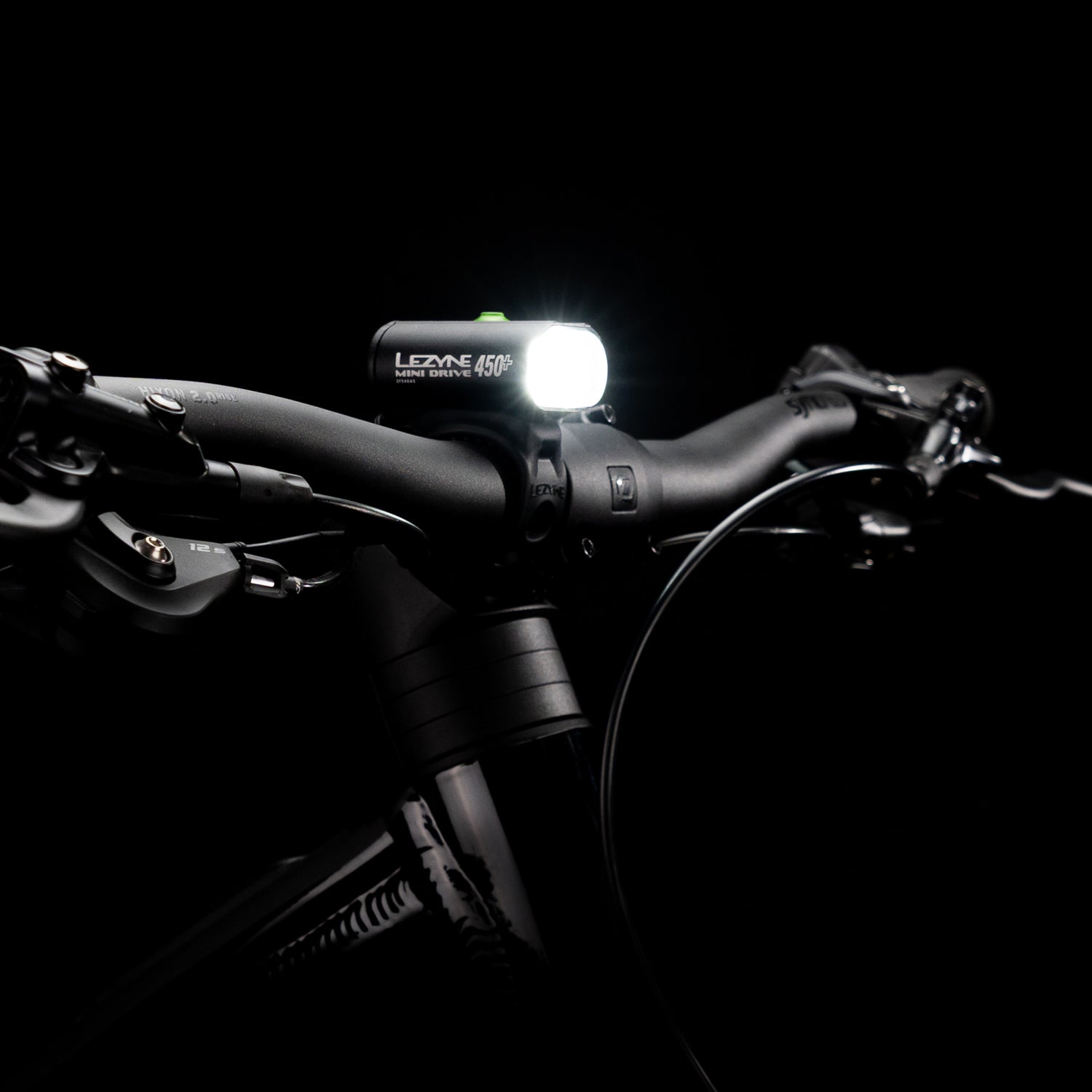 Studio shot of the Lezyne Mini Drive 450+ Front mounted on a bike handlebar