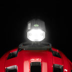 Front close-up studio shot of the Lezyne Helmet Fusion Drive 500+ with bright light beam mounted on a red helmet 
