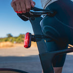 Rear perspective of a road bicycle equipped with the Radar Pro 300 taillight, highlighting its bright illumination during daylight.