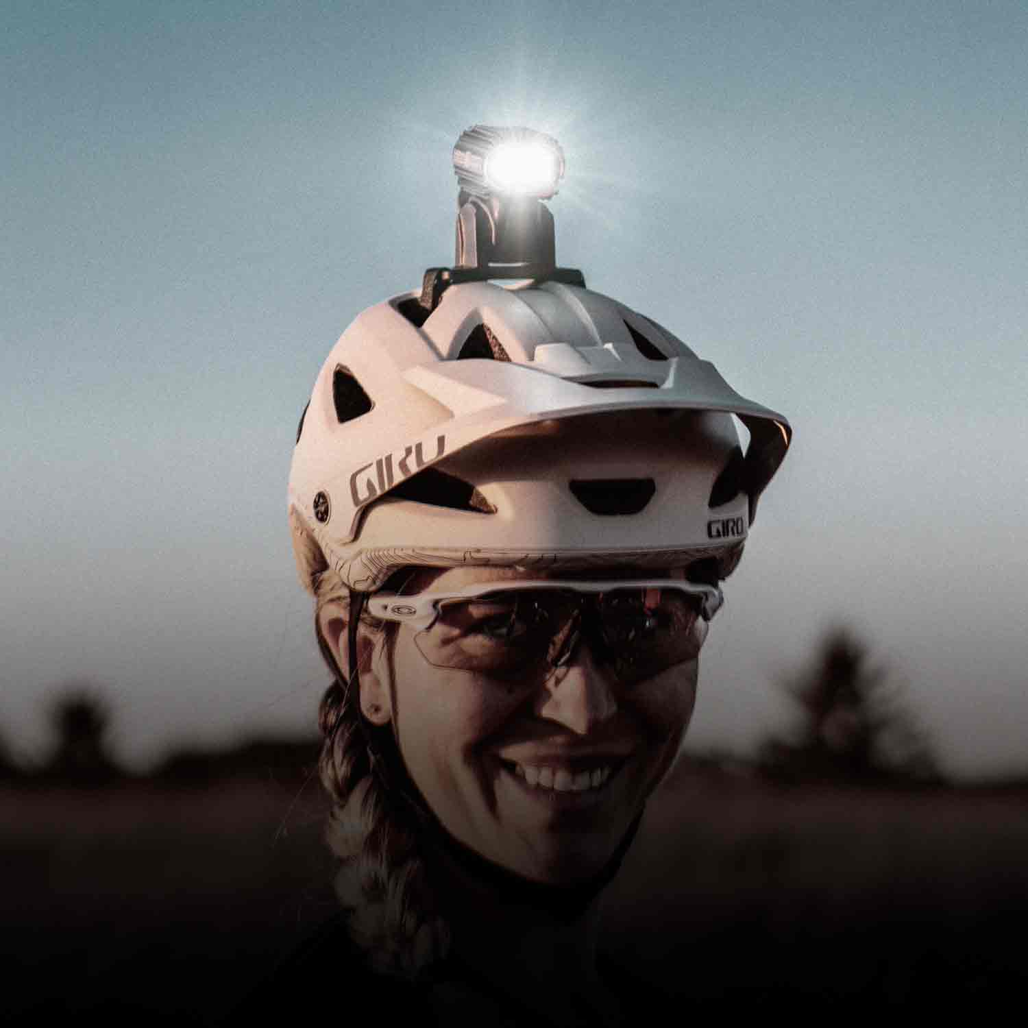 A woman's head wearing a helmet with a bright light attached to the top of it.