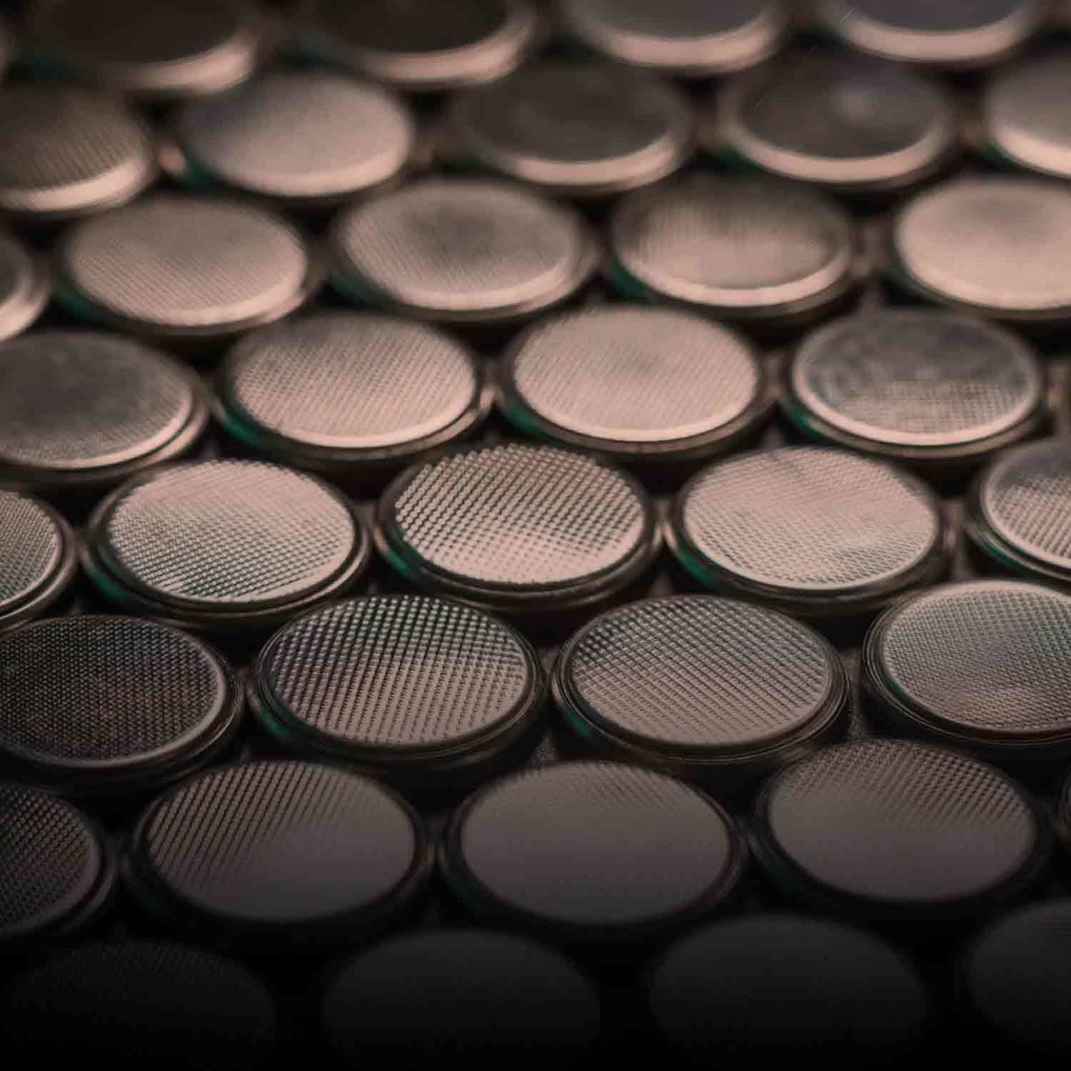 Many coin cell batteries arranged in a grid.