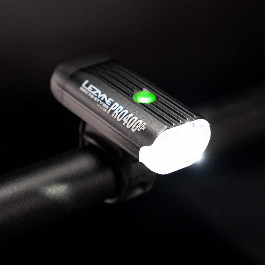 Side view of the Lezyne Hecto Pro StVZO 400+ headlight, a green circular power light on top of the casing, mounted on bike's handlebars.