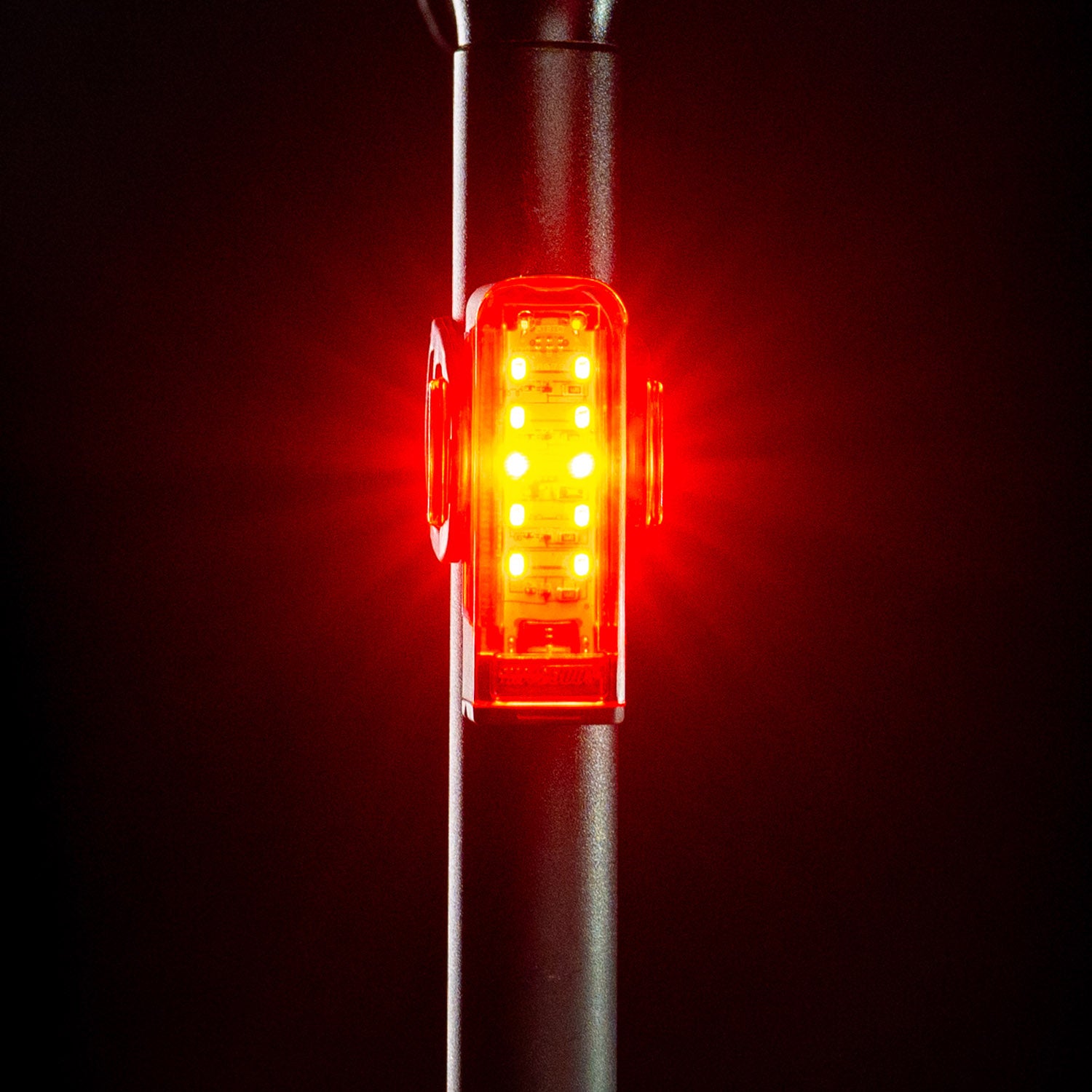 Front view of the Lezyne Strip+ StVZO Rear LED taillight, emitting a bright red light, mounted on the seatpost.