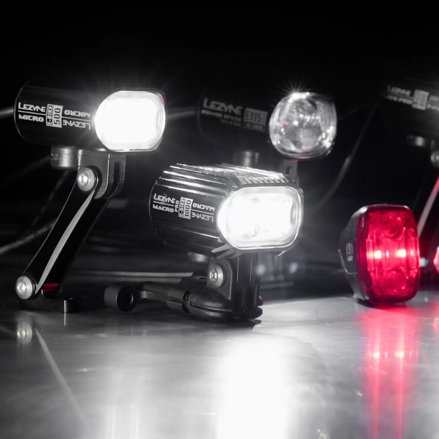 Several lights on a surface. Lezyne Macro E-BIKE 500 can be seen printed on the side of one of them.